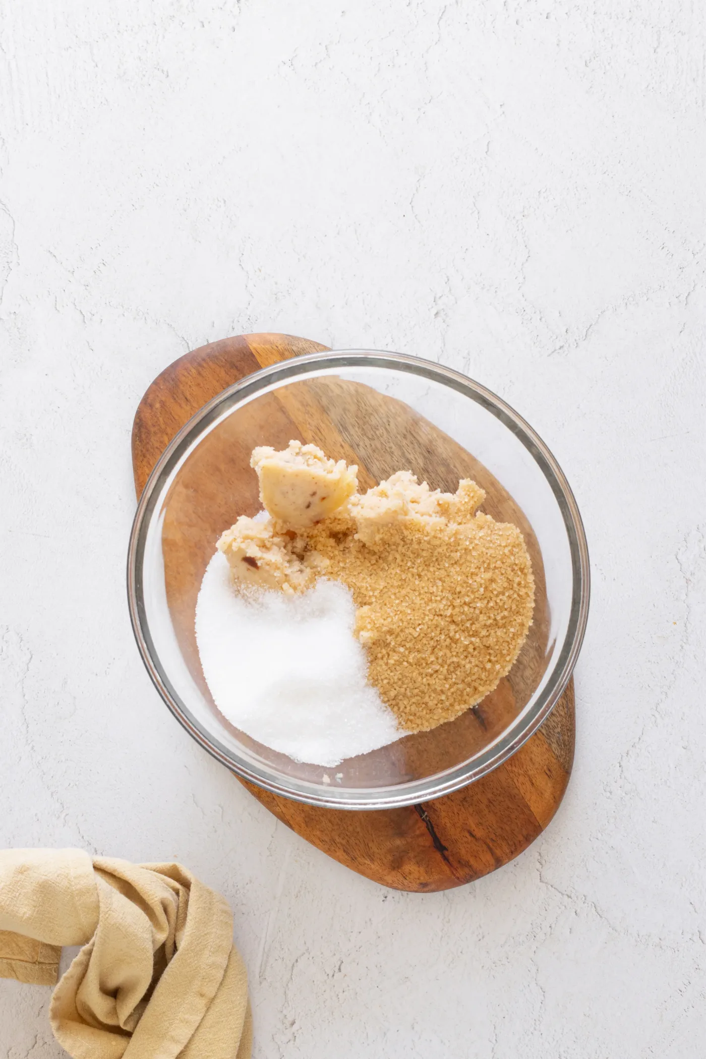 Chilled solid brown butter with granulated sugar and brown sugar in a glass bowl